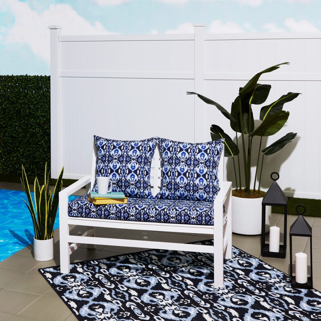 blue white and navy patterned rug underneath an outdoor bench 